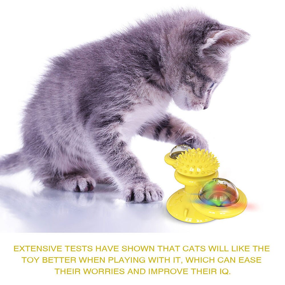 Gray kitten playing with a yellow toy on a white background