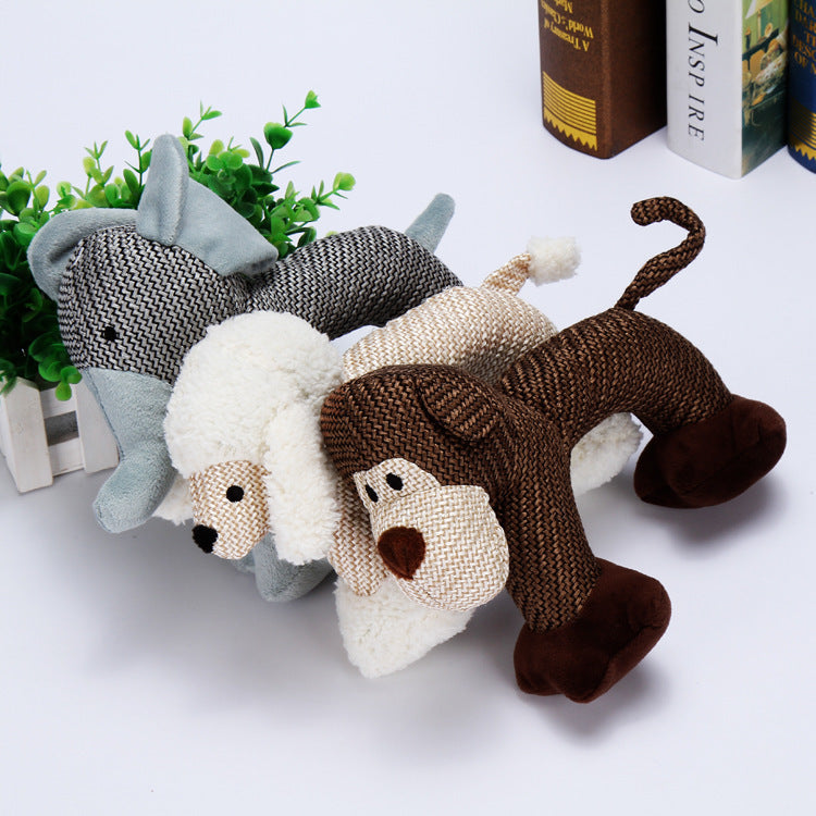 Three knitted dog toys in gray, white, and brown on a light surface with plants and books in the background.