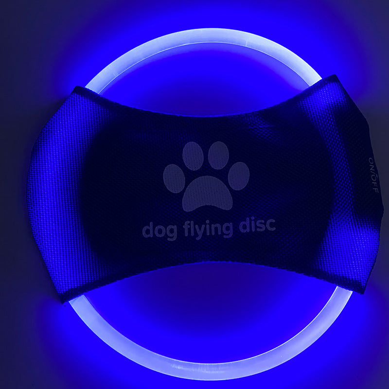 Blue and white dog flying disc with paw print design on a dark background