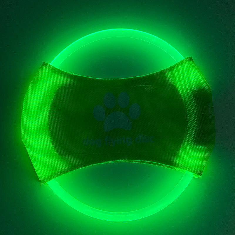 Green glowing dog collar with a paw print design on a dark background