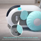 Close-up of a robot toy with buttons and a power indicator light on a neutral background.