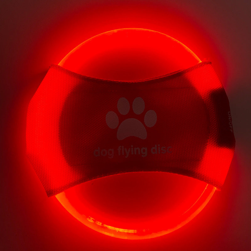 Red glowing dog flying disc with paw print design on a dark background
