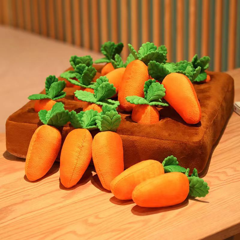 Plush carrots with green leaves on a wooden cutting board.
